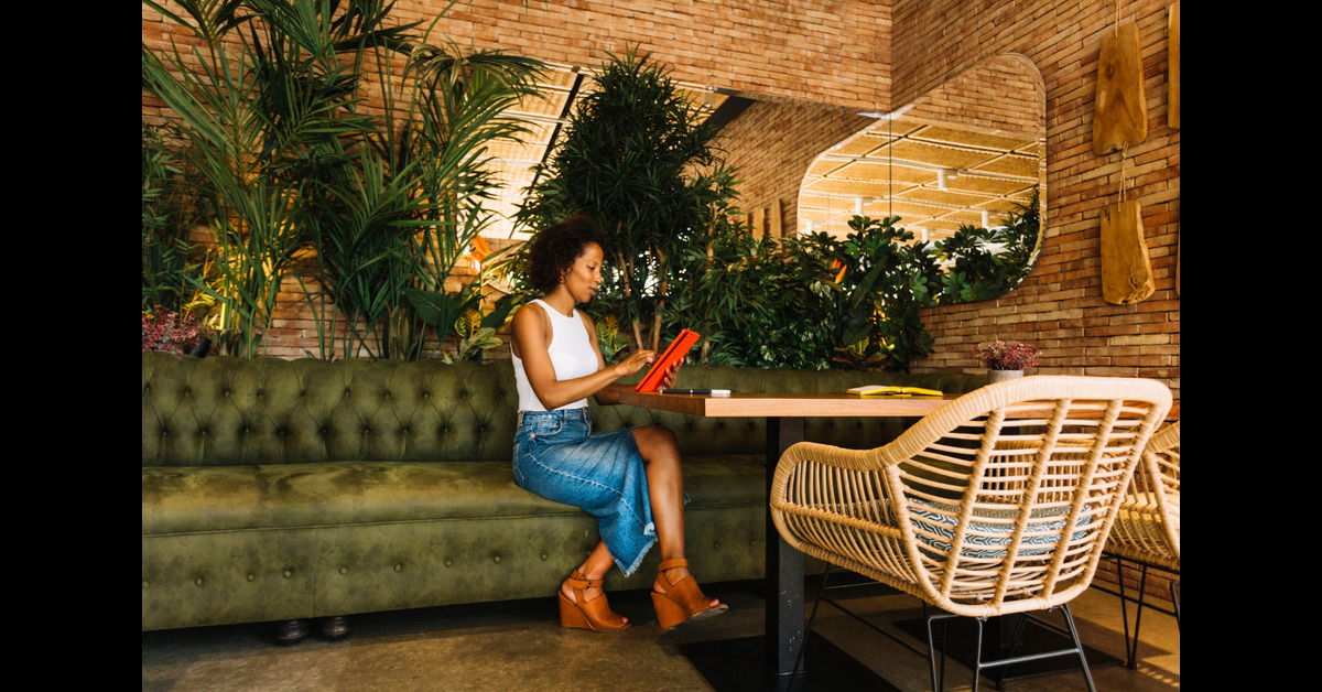 stylish young woman using digital tablet restaurant table (1)